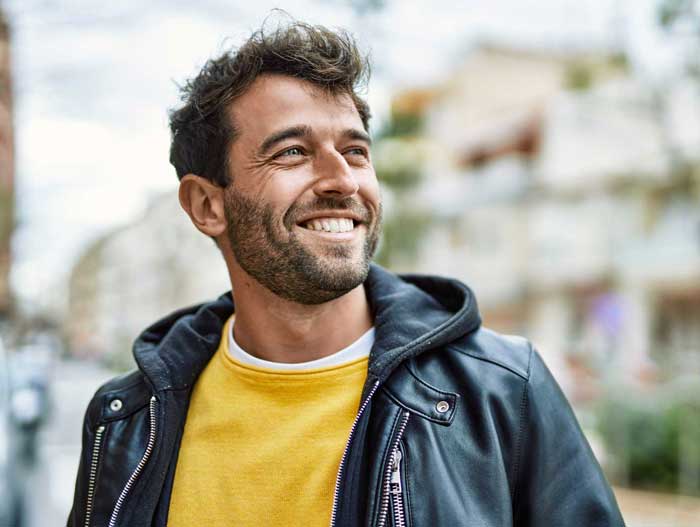Handsome hispanic man with beard smiling happy outdoors