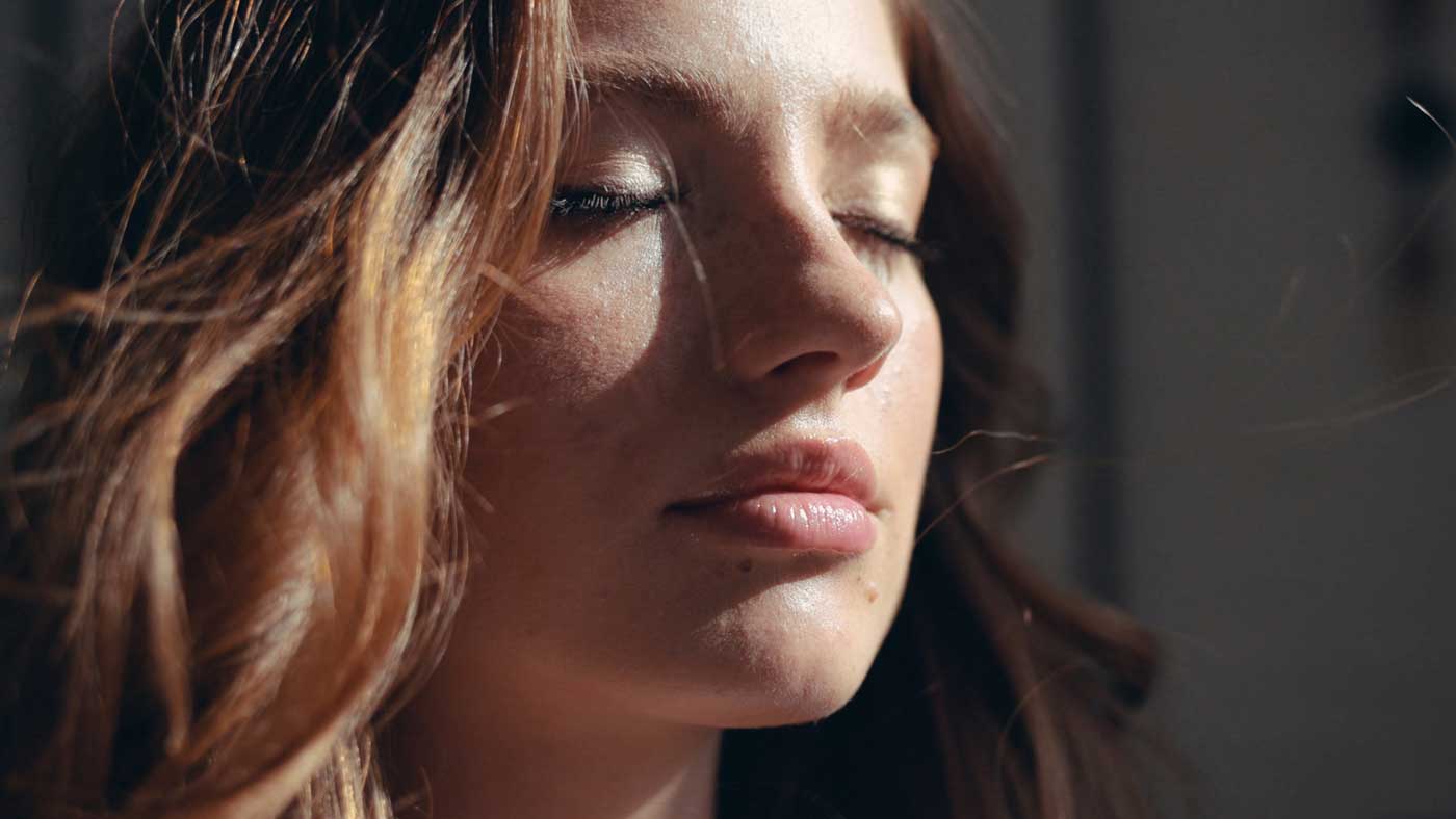 Young face woman at sunlight with curly hair fashion model with closed eyes female girl cosmetic beauty portrait confident happy cheerful enjoy relax close up